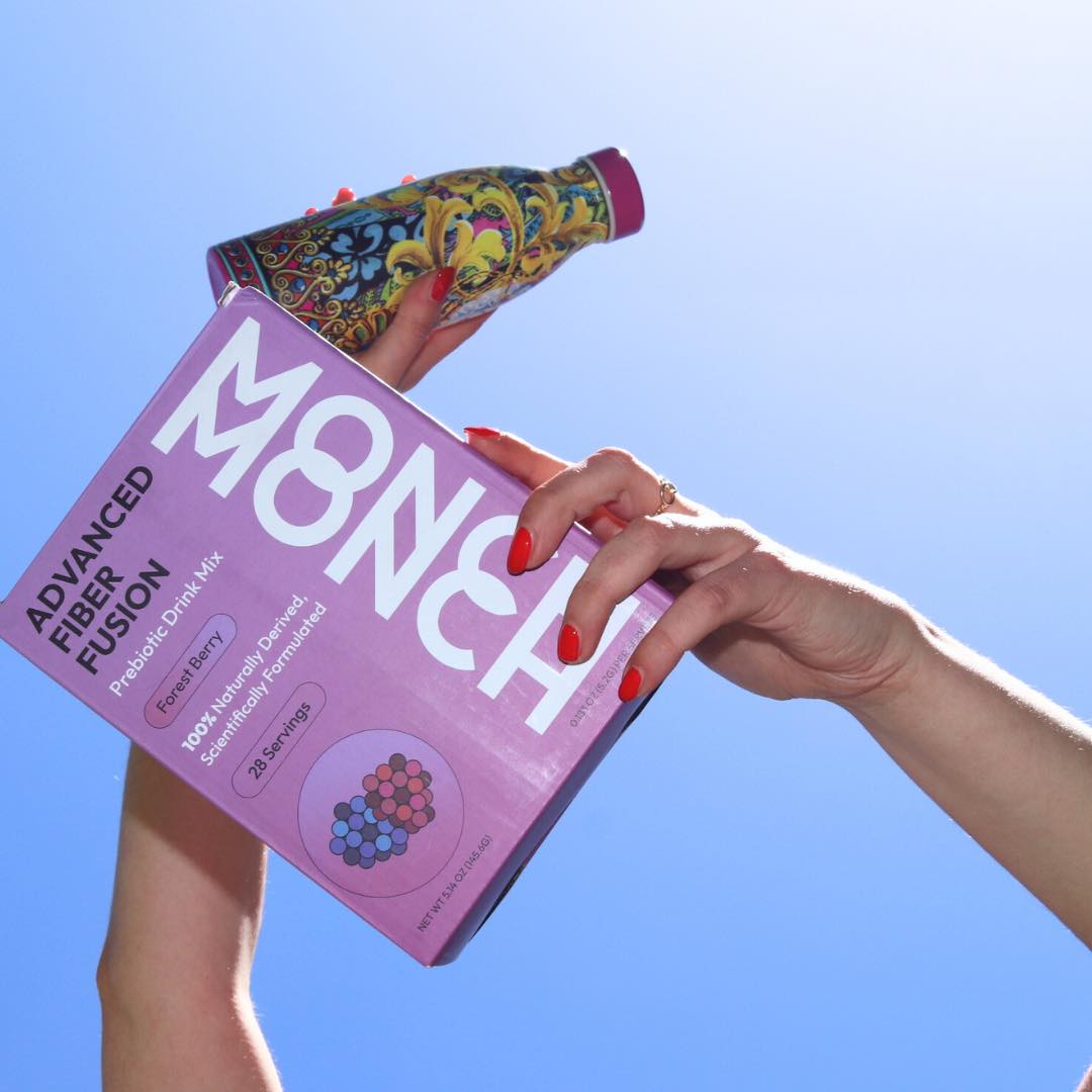 Monch Monch Forest Berry box held in the air alongside a bottle